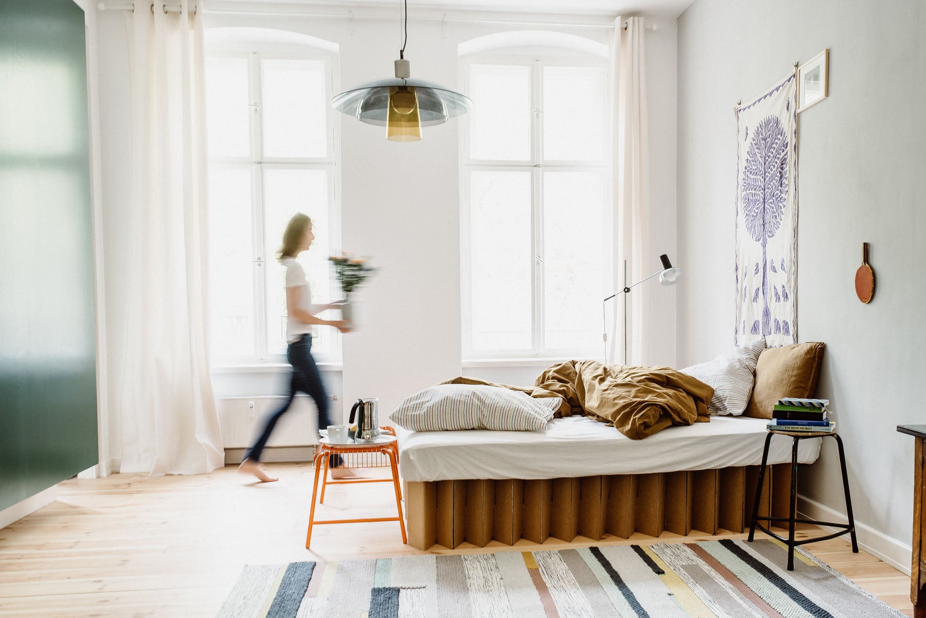 Bett 2.0, a 100% recyclable bed frame by RIAB USA, accented by blurred image background and multi-color rug