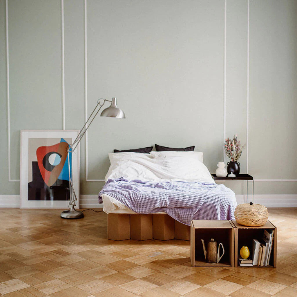twin size Bett 2.0, a premium cardboard bed frame by RIAB USA, on a parquet floor with modern furniture and natural light